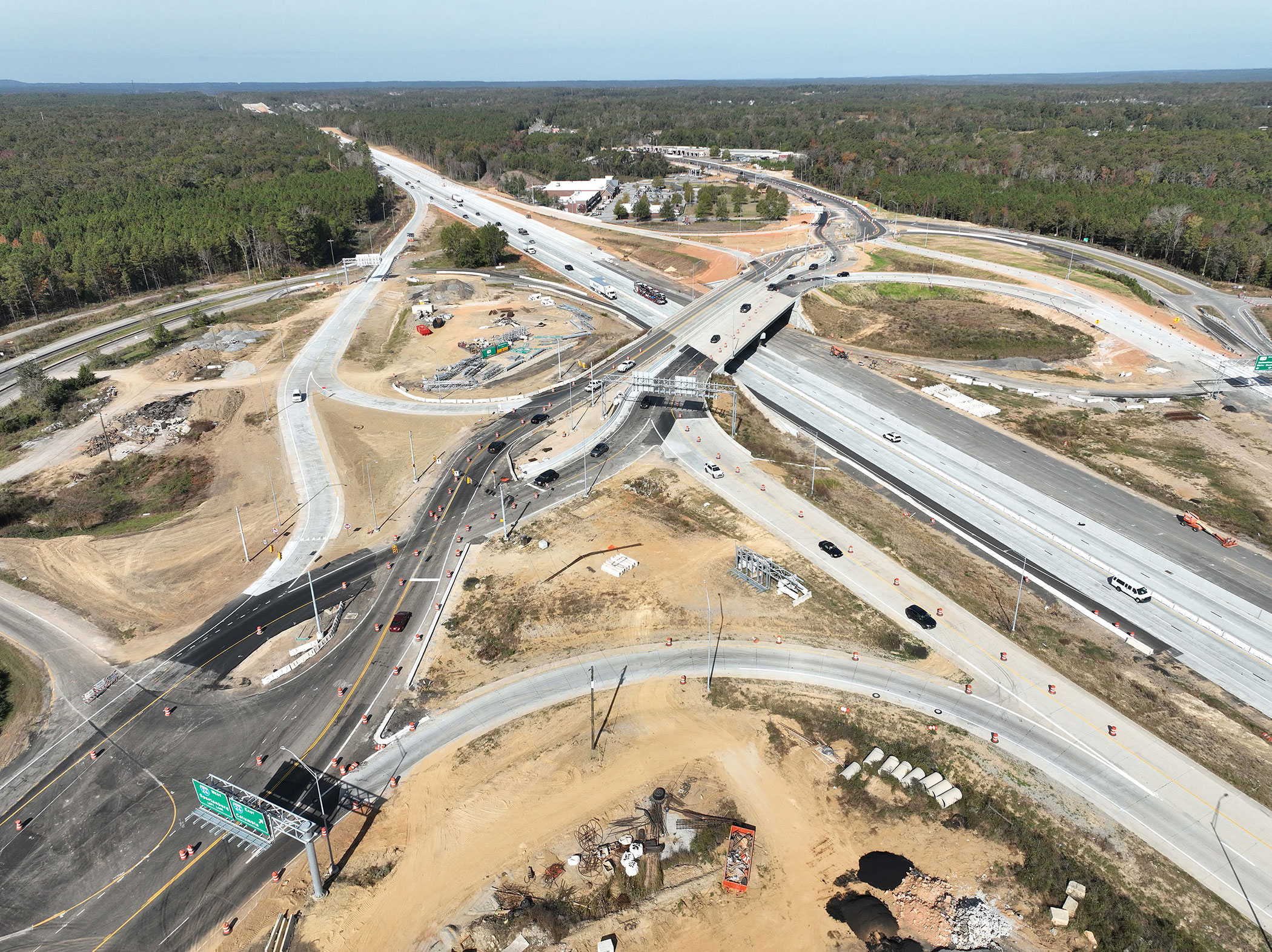 The interchange at Exit 97 has been converted to a Diverging Diamond Interchange (DDI). This type of interchange improves safety by eliminating many of the left turn movements that cross live traffic and providing free flow turns that reduce rear end collisions. The DDI is currently operating with one lane in each direction during this stage of construction, but will ultimately operate with two lanes in each direction