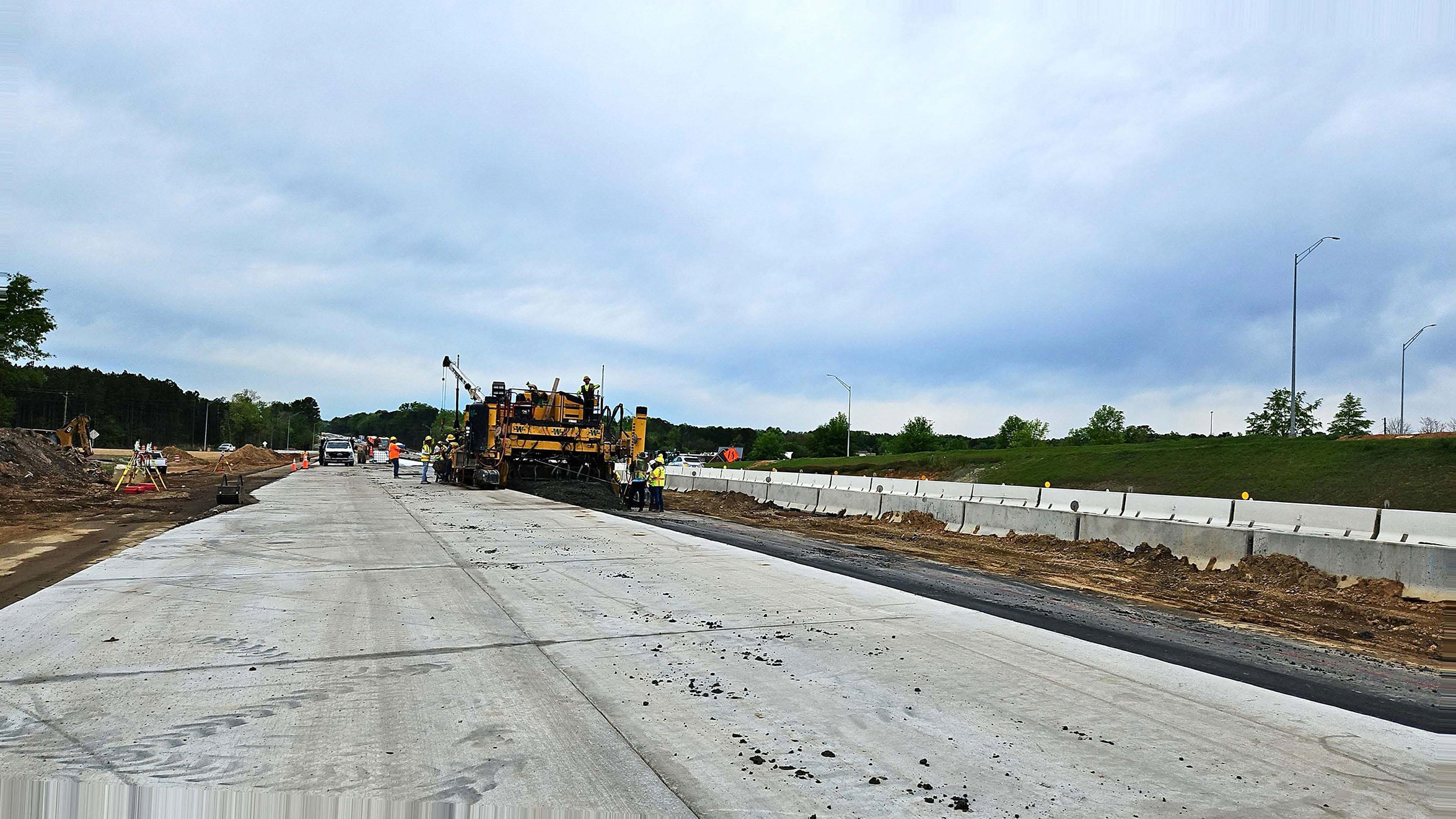 The paving crew continues placement of new travel lanes on I-26 near the Peak exit. This single lane paver rides along the top of the new pavement on one side and the top of the subbase on the other side.